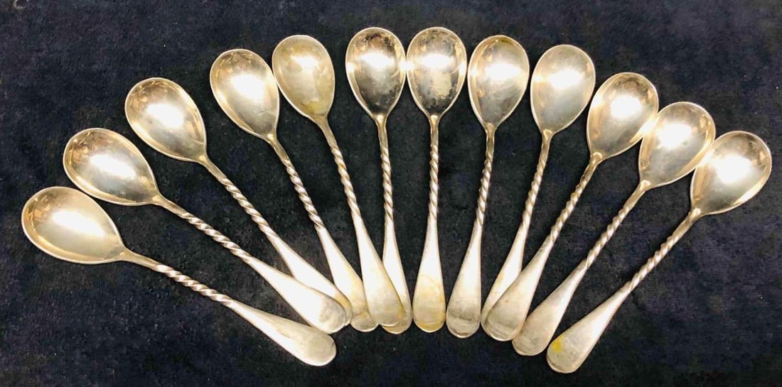 12 Solid Alaska Silver Spoons: This lot contains 12 Solid Alaska Silver Spoons. Each spoon is approx 4 3/4" x 1" x 1/4" and altogether they weigh about 0.3lbs. Overall the Spoons are in good used condition with some light wear from