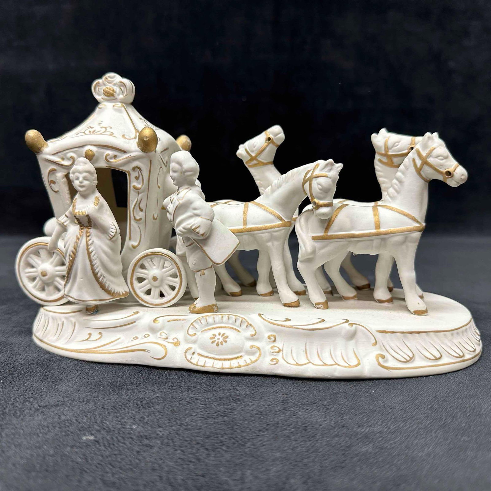 Bisque Carriage W Lady & Horses Figurine White Porcelain Repaired: This hand-painted bisque horse-drawn carriage figurine. It features a white carriage with gold toned accents, pulled by three white horses with gold accent harnesses. This porcelain piece has been rep