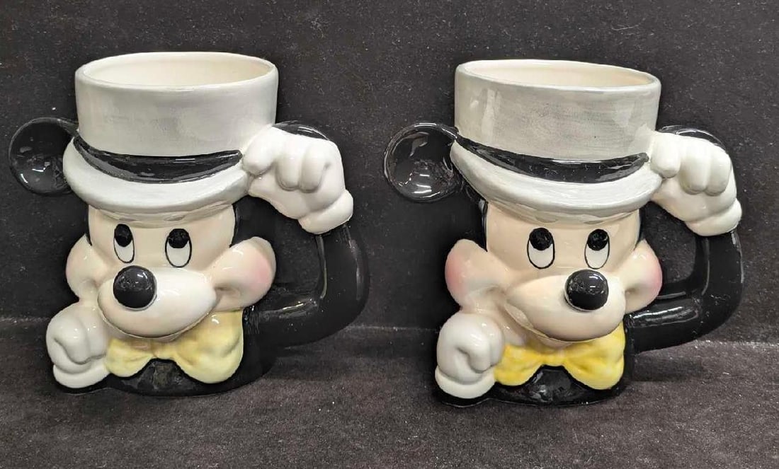 2 Vintage Disney Ceramic Top Hat Mickey Mouse Mug: 2 Vintage Disney Ceramic Top Hat Mickey Mouse Mug. The bottoms are marked, "Disney Japan". Each is approx 5 1/4" x 6 1/2" x 5" and the total weight is 1.41lb. There is a chip around the nose of one of
