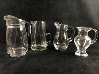 A Mixed Lot Of 4 Clear Glass Serving Water Liquid Pitcher Flower Vase Denizh Curvy Tall Pinch Spout: A Mixed Lot Of 4 Clear Glass Serving Water Liquid Pitcher Flower Vase Denizh Curvy Tall Pinch Spout  This lot features 4 clear glass drinking pitchers with a pinch pour spout. All the pitchers are in