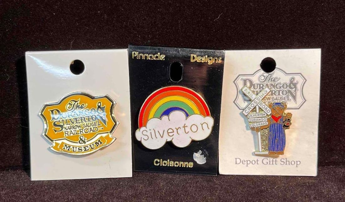 Three The Durango & Silverton Museum Enamel Pins (F18): This lot contains Three The Durango & Silverton Museum Enamel Pins (F18). The pins fit together in a small 6 3/4" x 4" plastic bag and altogether they weigh about 0.7oz. Overall the pins are in good u