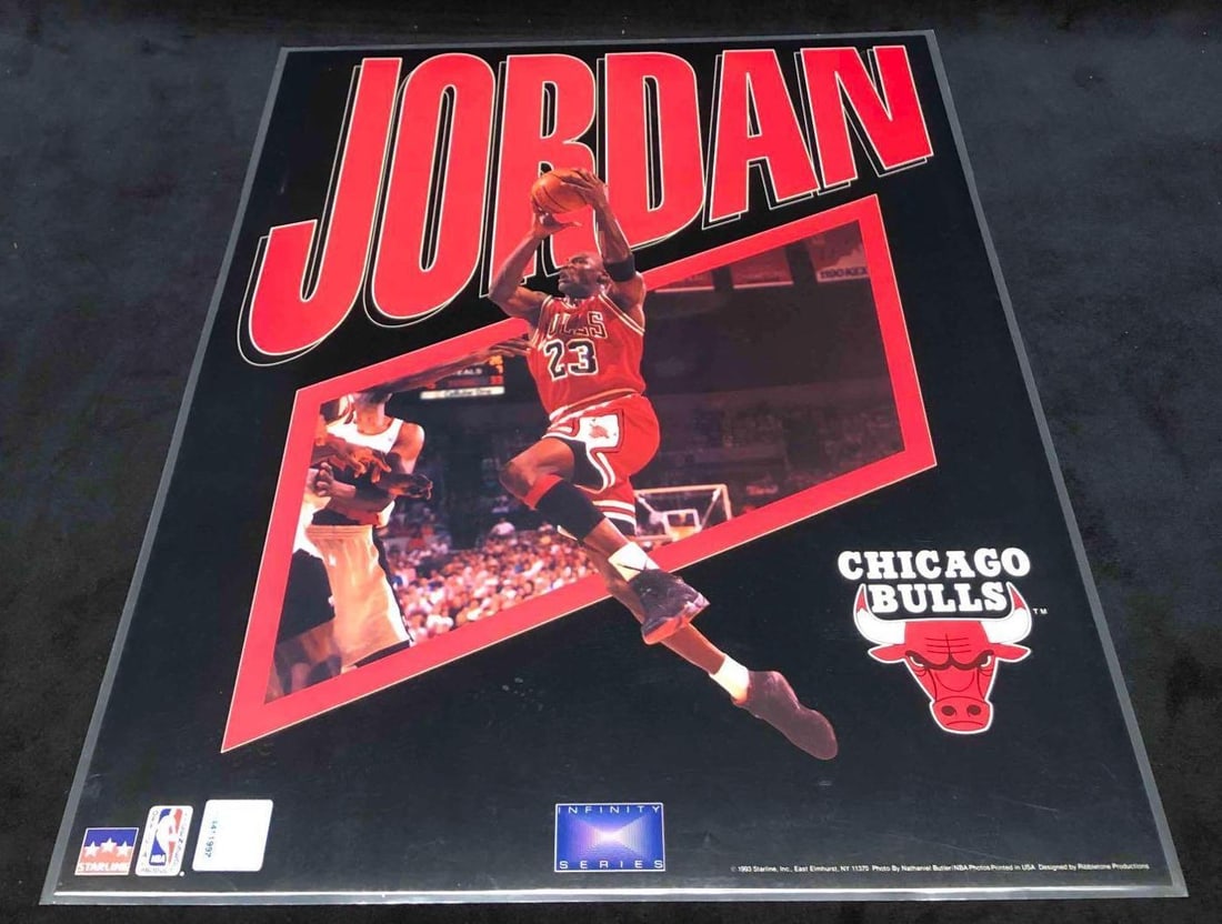 Laminated Photograph Of Michael Jordan Starline Inc. Photo By Nathaniel Butler NBA Phots1993: This lot contains a laminated photograph of Michael Jordan Chicago Bulls Sarline Inc. photo by Nathaniel Butler NBA Phots 1993. The image shows a cut out of MJ has he goes for a two handed dunk. It is