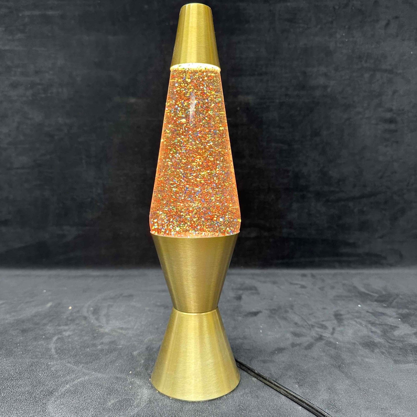Lava Lamp Motion And Rainbow Glitter Model 2131 Clear Gold: The original Lava Lamp model 2131, the lamp takes glitter to a whole new level by mixing the beauty of a shiny, gold globe with the extreme sparkle of rainbow glitter. A hand-spun aluminum base and mu