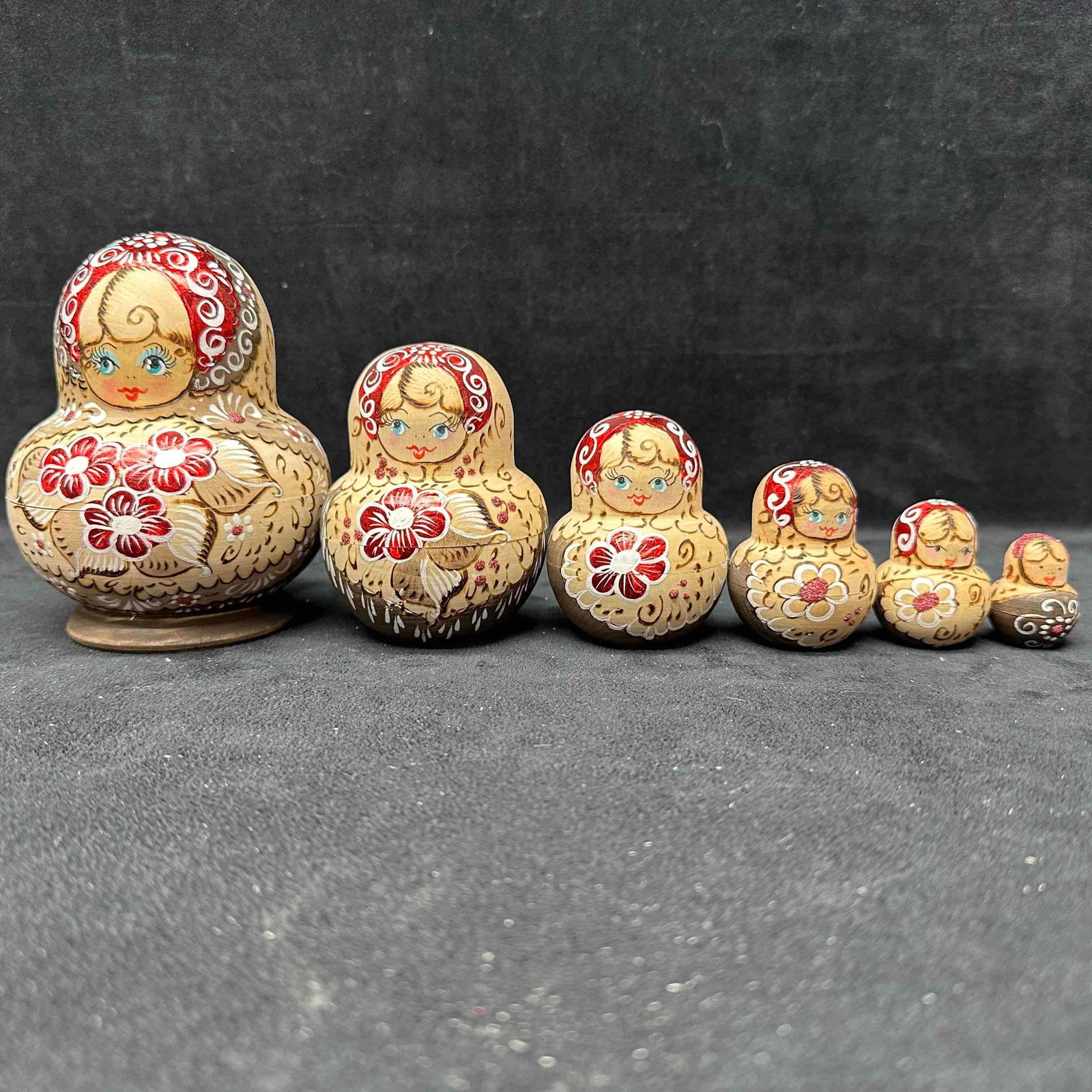 Wood Russian Matryoshka Nesting Dolls Six Piece Hand-Painted Wooden Set: Wooden 6-piece Russian Matryoshka nesting doll set, hand-painted with red kerchiefs and floral designs in red, white, and gold. Largest doll approx. 5" tall. Original label on the base. Dolls fit