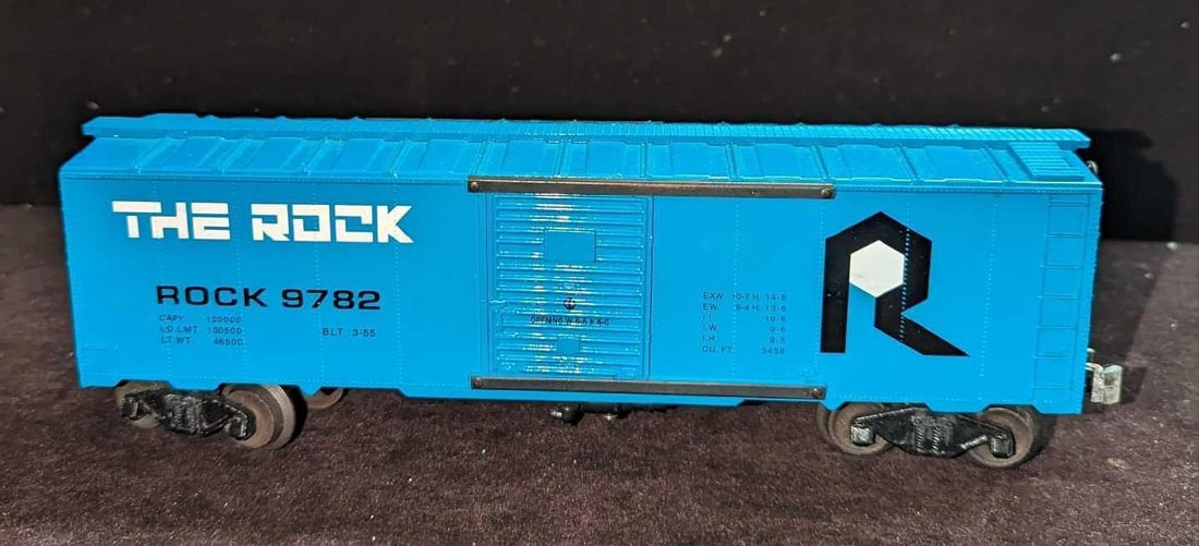 Vintage 0 Scale The Rock 9782 Boxcar: Vintage 0 Scale The Rock 9782 Boxcar. This is approx 11 1/2" x 2 3/8" x 3 1/8" and it weighs 0.94lb. The metal couplers have turned white and the top has signs of wear.