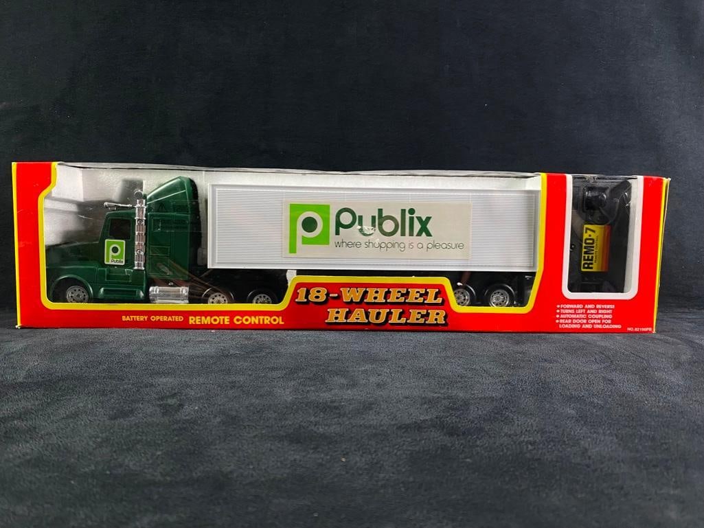 Publix Battery Operated Remote Control 18-Wheeler: Publix Battery Operated Remote Control 18-Wheeler. Still in its original box. Forward and reverse! Turns left and right! Automatic coupling! The rear door is open for loading and unloading. Comes with