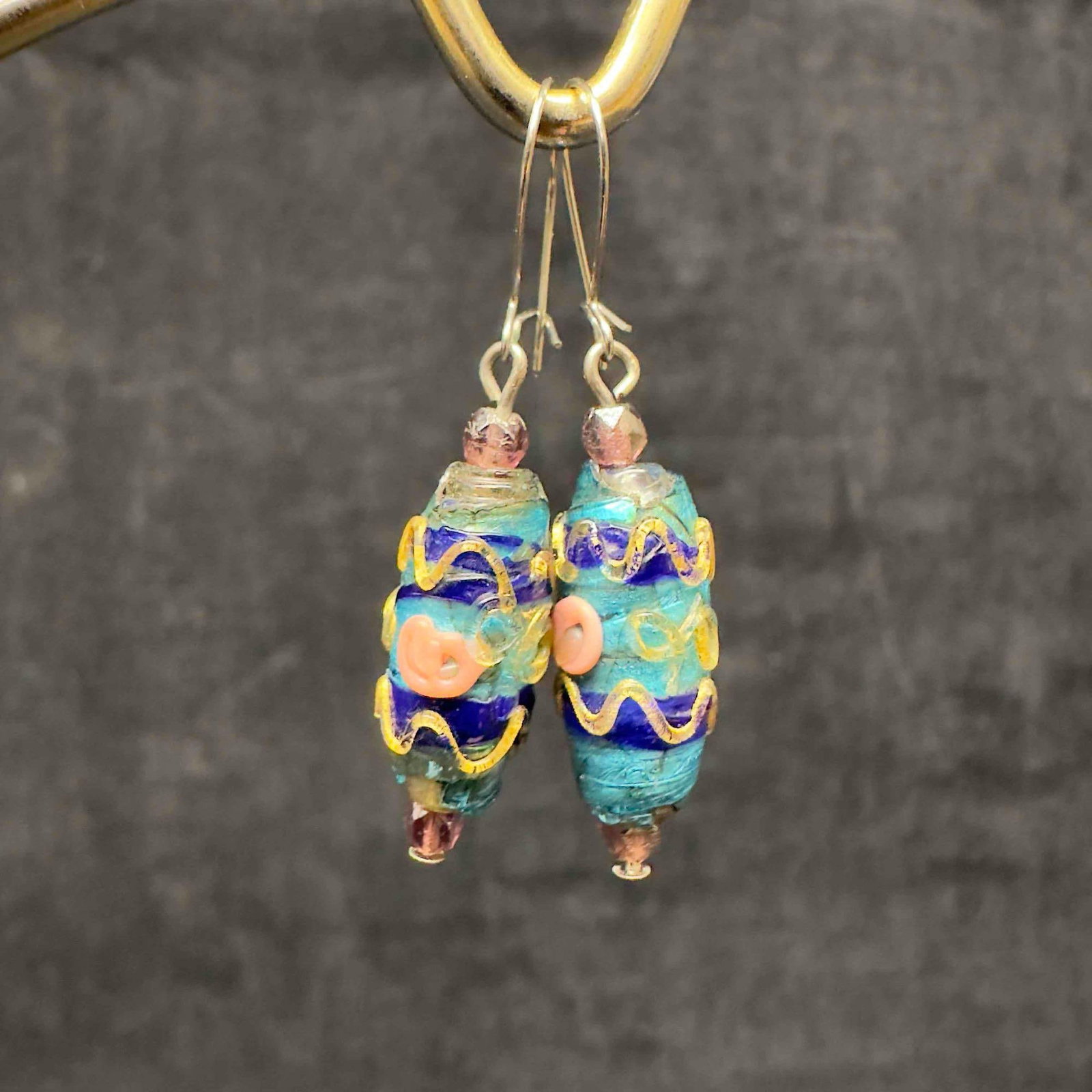 Murano Venetian Art Glass Lamp Work Teal Blue Bead Drop Dangle Earrings H28: Murano Venetian Art Glass Lamp Work Teal Blue Bead Drop Dangle Earrings H28. Earrings with blue teal colored glass beads with beautiful designs on each. The earrings feature gold toned accents. The ea