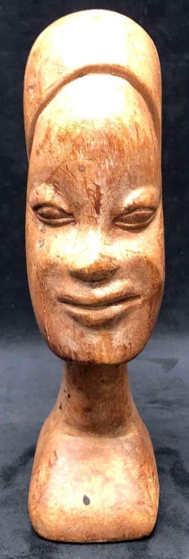 Carved Wood Head Of An African Woman: This lot contains a carved wood head of an African woman. This artwork is perfect for use as table decor. It is approx. 4" x 2 1/2" x 10 1/4" and weighs about 1.4lbs. The carving is in good used condi