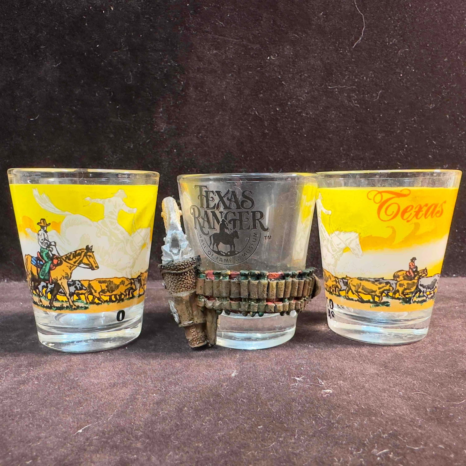 Texas Shot Glass Set of Three Glasses Ranger Hall of Fame Waco Cowboy: Texas Shot Glass Set of Three Glasses Ranger Hall of Fame Waco Cowboy. This lot of Texas shot glasses feature a Ranger Hall of Fame and Museum gun holster glass. And two Waco Texas cowboy orange sunse