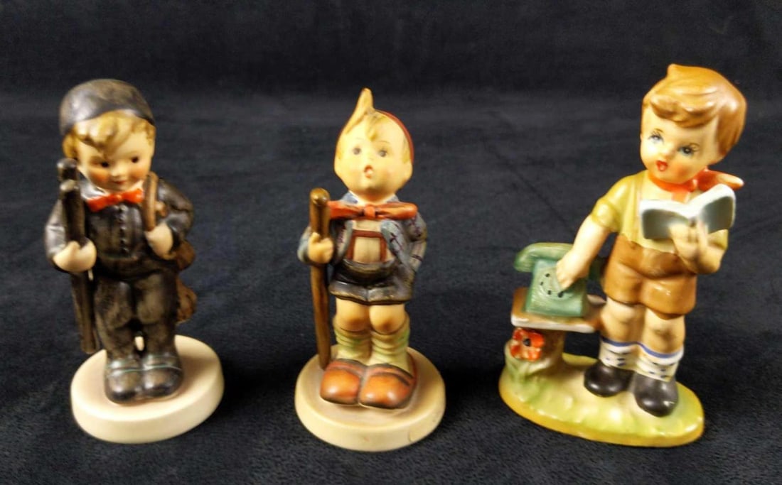 2 Vintage Goebel Hummel Figurines And 1 Imitation: This lot includes: (1) Chimney Sweep. 12 2/0 HUM. TMK-6. Figurine is approx 2" x 2" x 4". Figurine is in good, vintage condition with no known damage. (1) The Little Hiker. 76 2/0 HUM. TM