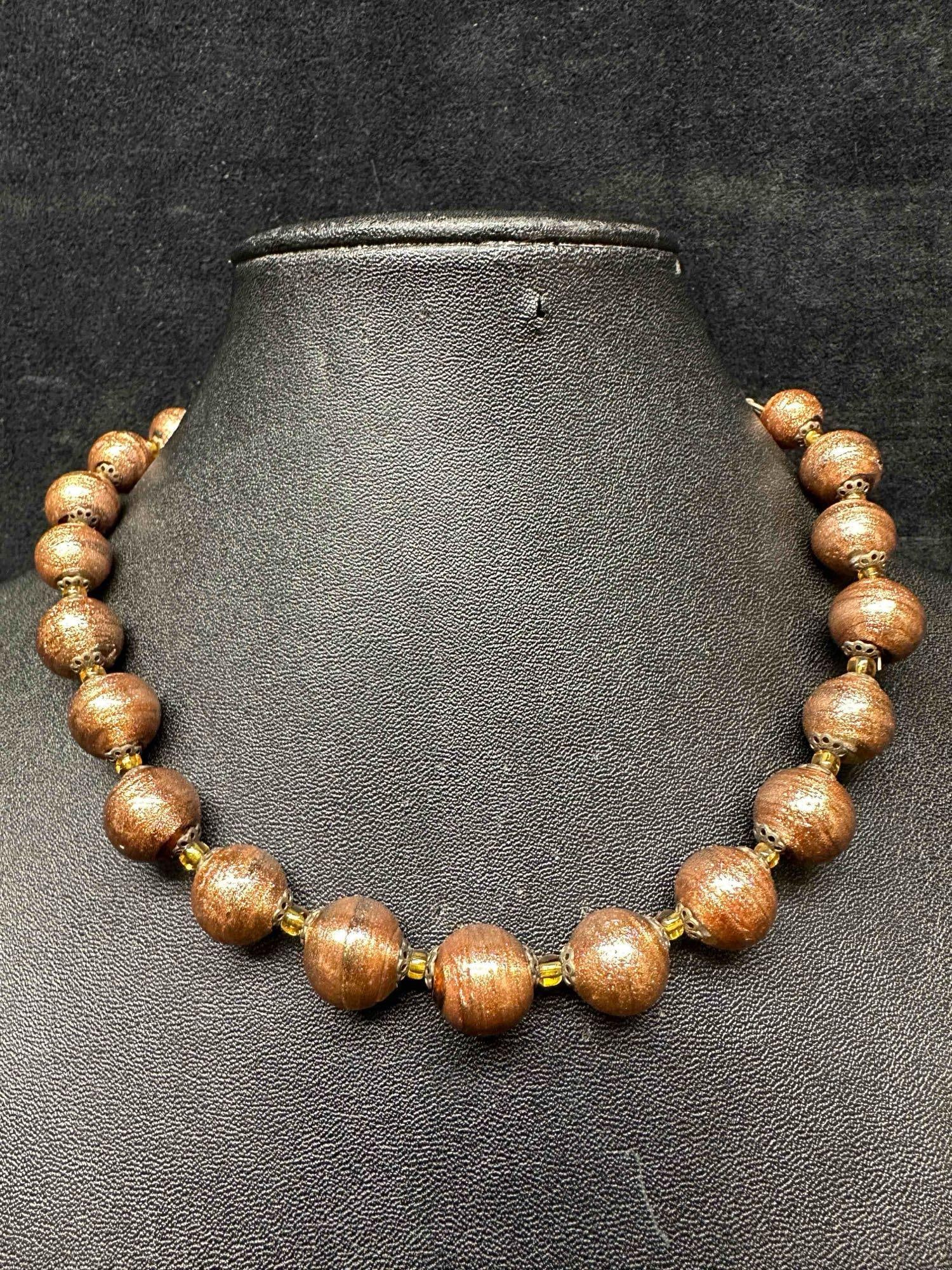 Murano Venetian Lamp Work Art Glass Round Bead Brown Copper Beaded Necklace E97: Murano Venetian Lamp Work Art Glass Round Bead Brown Copper Beaded Necklace E97. Necklace with brown colored glass beads with a beautiful design on each. The necklace features copper colored accents.