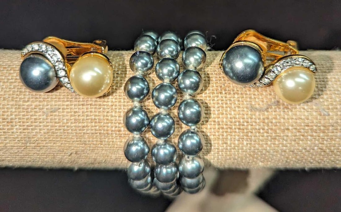Kenneth Jay Lane Triple Strand Faux Gray Pearl Bracelet & Earrings: This lot includes: (1) Kenneth Jay Lane Triple Strand Faux Gray Pearl Bracelet. With gold-tone clasps. This is approx 8 1/2". (1) Kenneth Jay Lane Faux Pearl & Crystal Crossover Clip-On Earrin