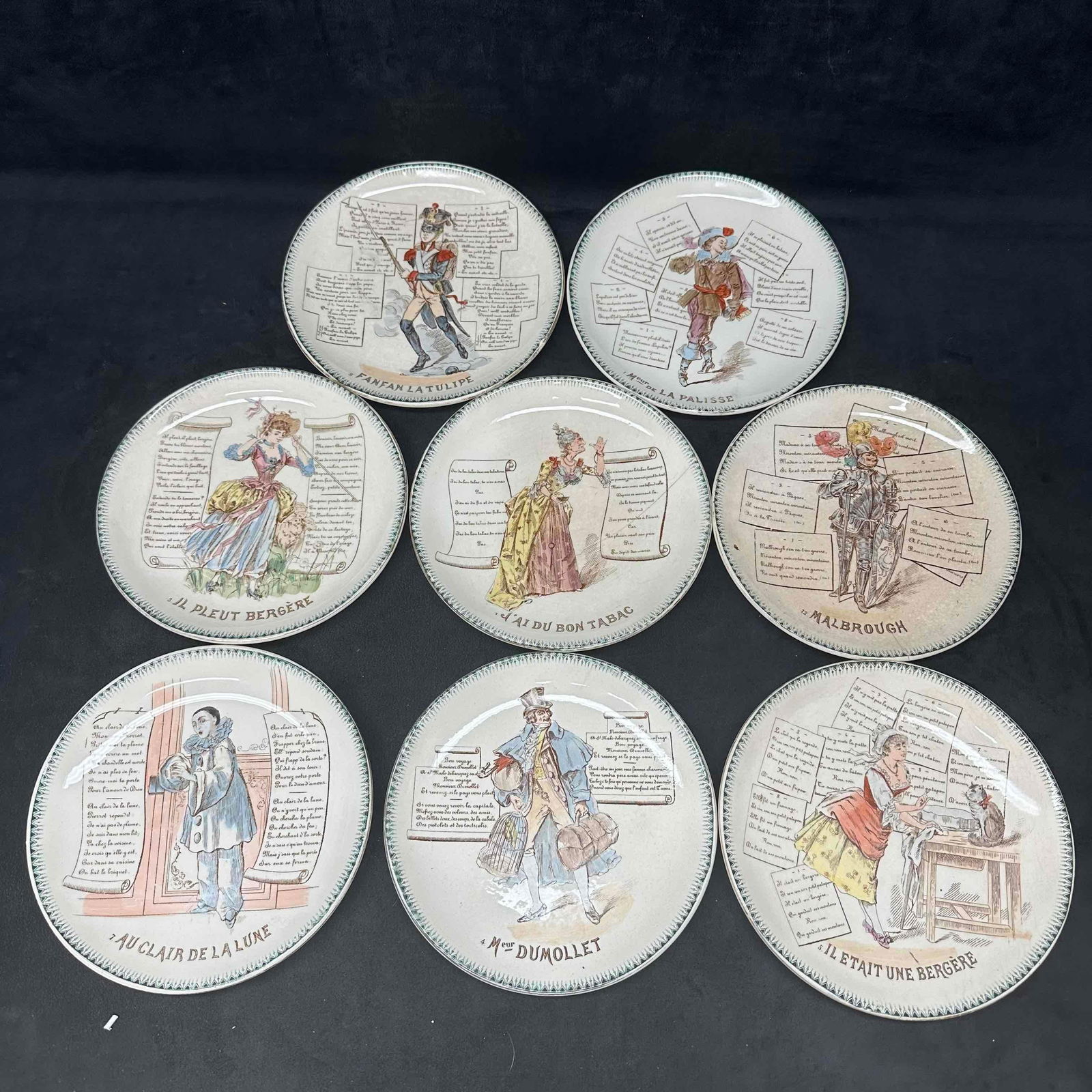 Eight French Terre De Fer HB CIE Plate Set Talking Collectible Plates: Eight French Terre De Fer HB CIE Plate Set Talking Collectible Plates. One plate has a crack in the plate. Each piece has makers mark on the bottom of the plate. These items are in good pre-owned, con
