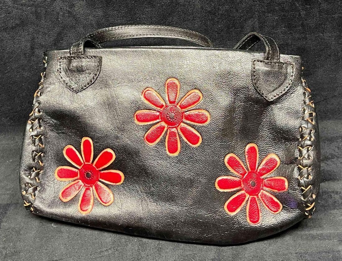 Vintage Leather Handicraft Purse With Embossed Flowers (18): This lot contains a Vintage Leather Handicraft Purse With Embossed Flowers (18). The bag is hand-stitched and has a very soft leather liner and inside zipper pocket. It is approx 10 1/2" x 2 1/4" x 7"