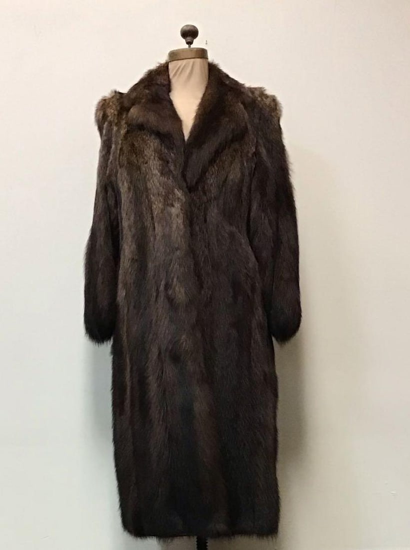 Luxury Brown Raccoon Fur Coat: Luxury Brown Raccoon Fur Coat. Made by an unknown manufacturer. This coat features two exterior pockets, brown interior linen and three hook and clips. It is in good used condition with no known damag