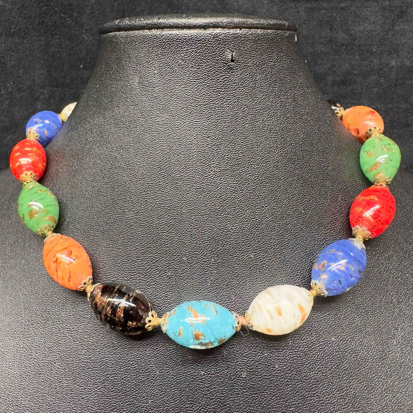 Murano Venetian Art Glass Lamp Work Multi Colored Oval Bead Copper Beaded Necklace C67: Murano Venetian Art Glass Lamp Work Multi Colored Oval Bead Copper Beaded Necklace C67. Necklace with multi colored glass beads with beautiful designs on each. The necklace features copper colored acc