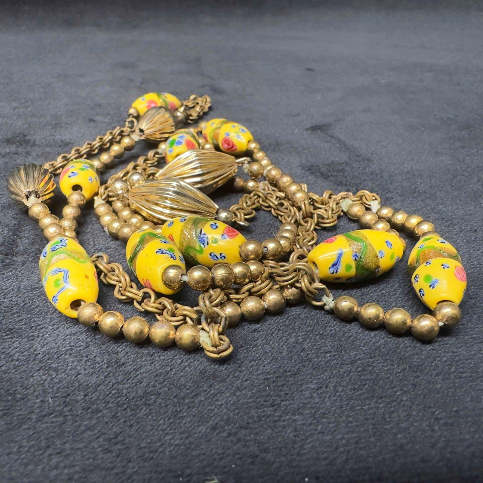 Murano Venetian Lamp Work Art Glass Yellow Beaded Gold Toned Accents Long Lariat Necklace G14: Murano Venetian Lamp Work Art Glass Yellow Beaded Gold Toned Accents Long Lariat Necklace G14. Necklace with yellow colored glass beads with beautiful designs on each. The necklace features gold toned