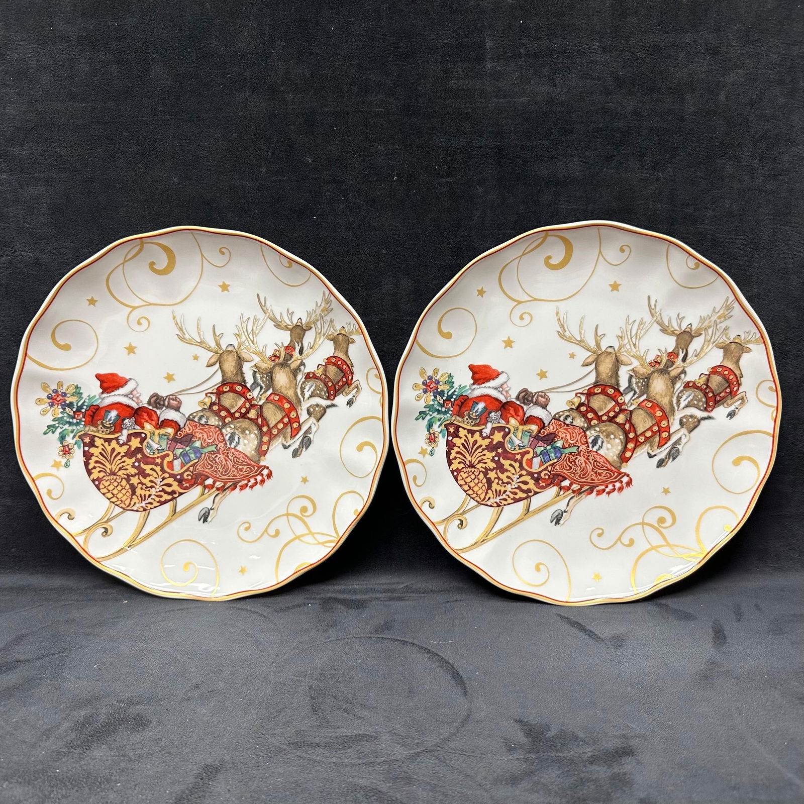Twas the Night Before Christmas Dinner Plates Santa and Sleigh Set: Pair of Williams-Sonoma porcelain plates featuring a colorful holiday design of Santa Claus in his sleigh pulled by reindeer, decorated with scrolling gold accents and star details. Marked on reverse