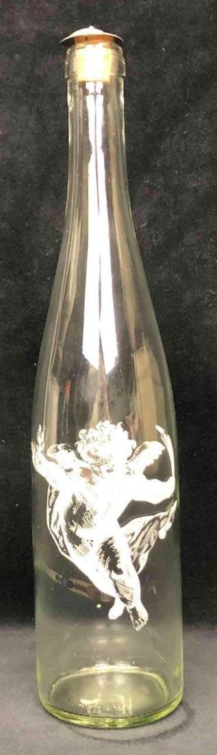Vintage Bottle Etched With A Cherub: This lot contains a vintage glass bottle with an etched cherub on the front. The artist of this work is unknown. The bottle is approx 13 1/2" x 3" and weighs about 1.0lbs. The bottle is in good vintag