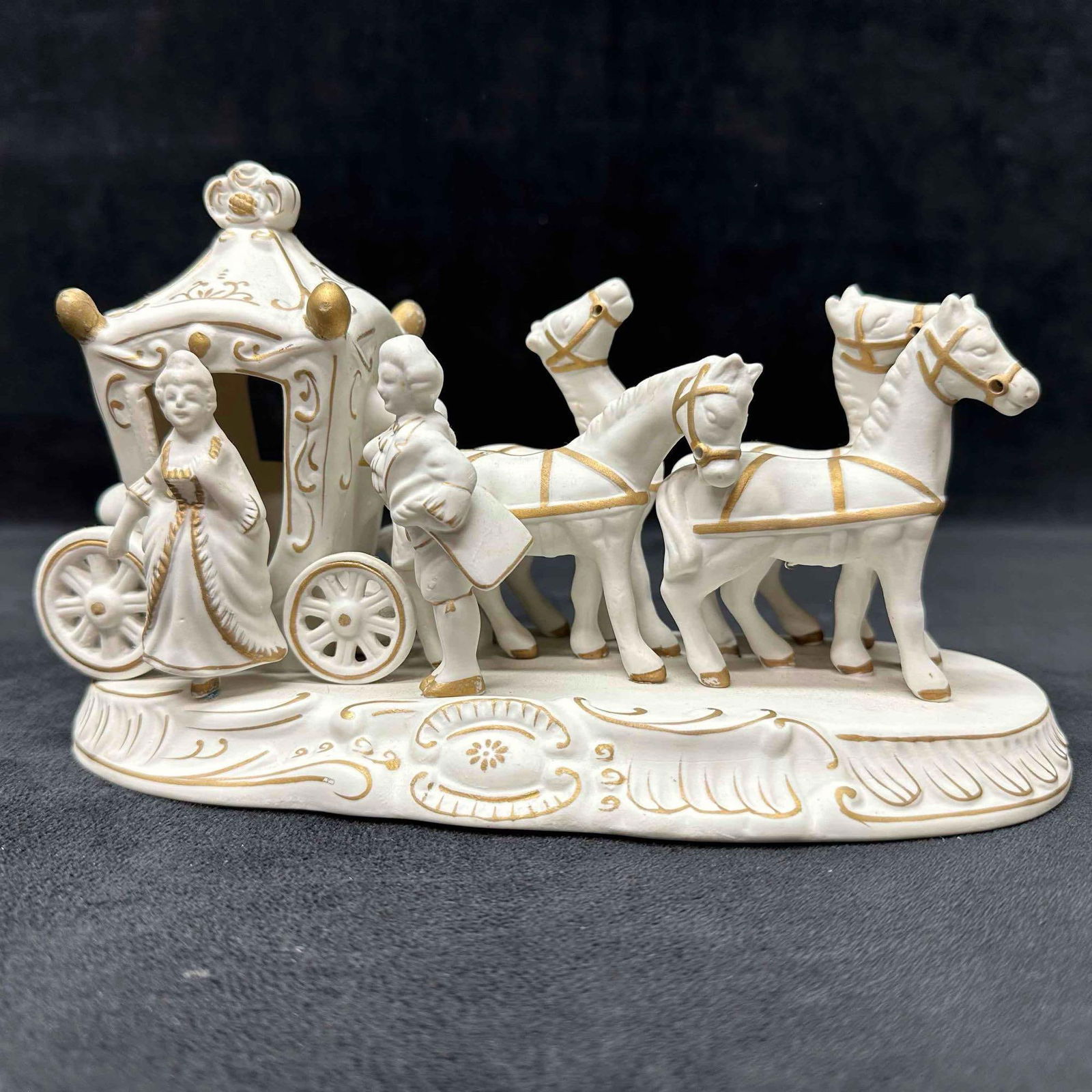 Bisque Carriage W Lady & Horses Figurine White Porcelain Repaired: This hand-painted bisque horse-drawn carriage figurine. It features a white carriage with gold toned accents, pulled by three white horses with gold accent harnesses. This porcelain piece has been rep