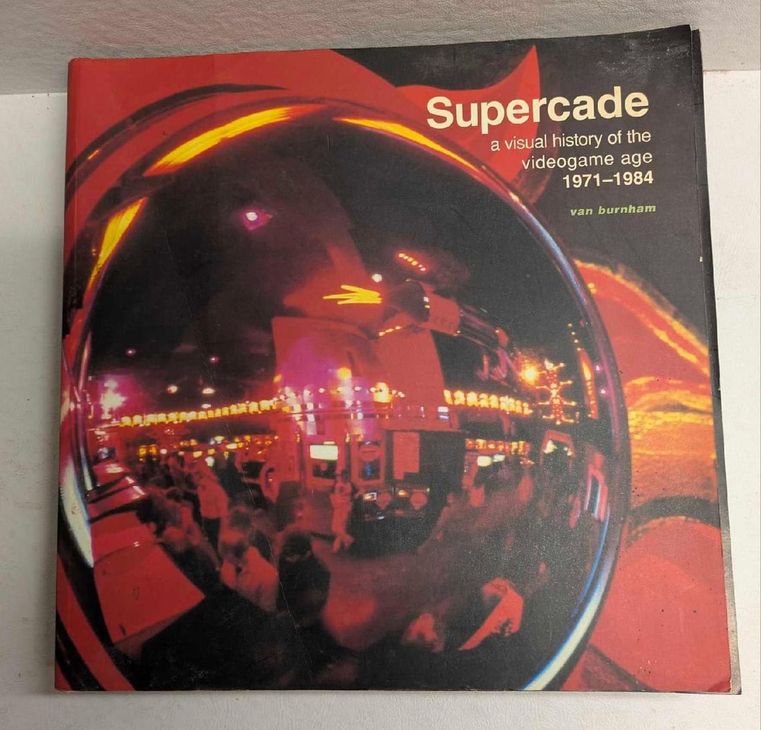 Supercade A Visual History Of The Videogame Age Softcover: Supercade A Visual History Of The Videogame Age. "1971 to 1984". By Van Burnham. This was released in the year 2003. The softcover book is approx 10" x 10" x 1" and it weighs 4.35lbs. The spine/