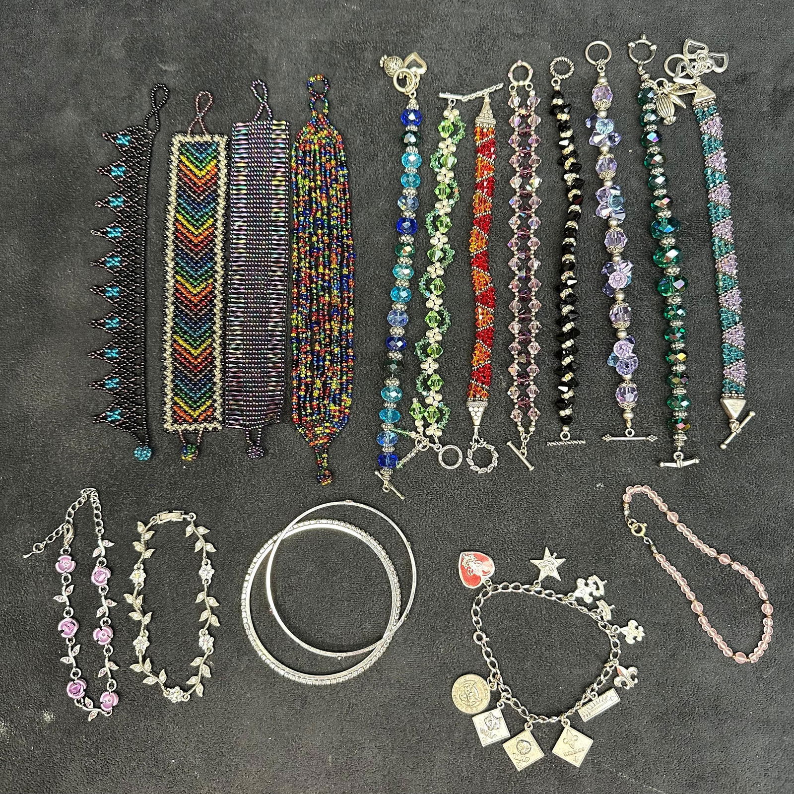 Lot of Sixteen Vintage and Handmade Beaded Charm Bracelets Mixed Styles and Colors: Collection of 18 assorted bracelets, including a colorful mix of handcrafted beaded, crystal, rhinestone, and charm bracelets. Designs feature a range of styles and materials, such as Intricately wove