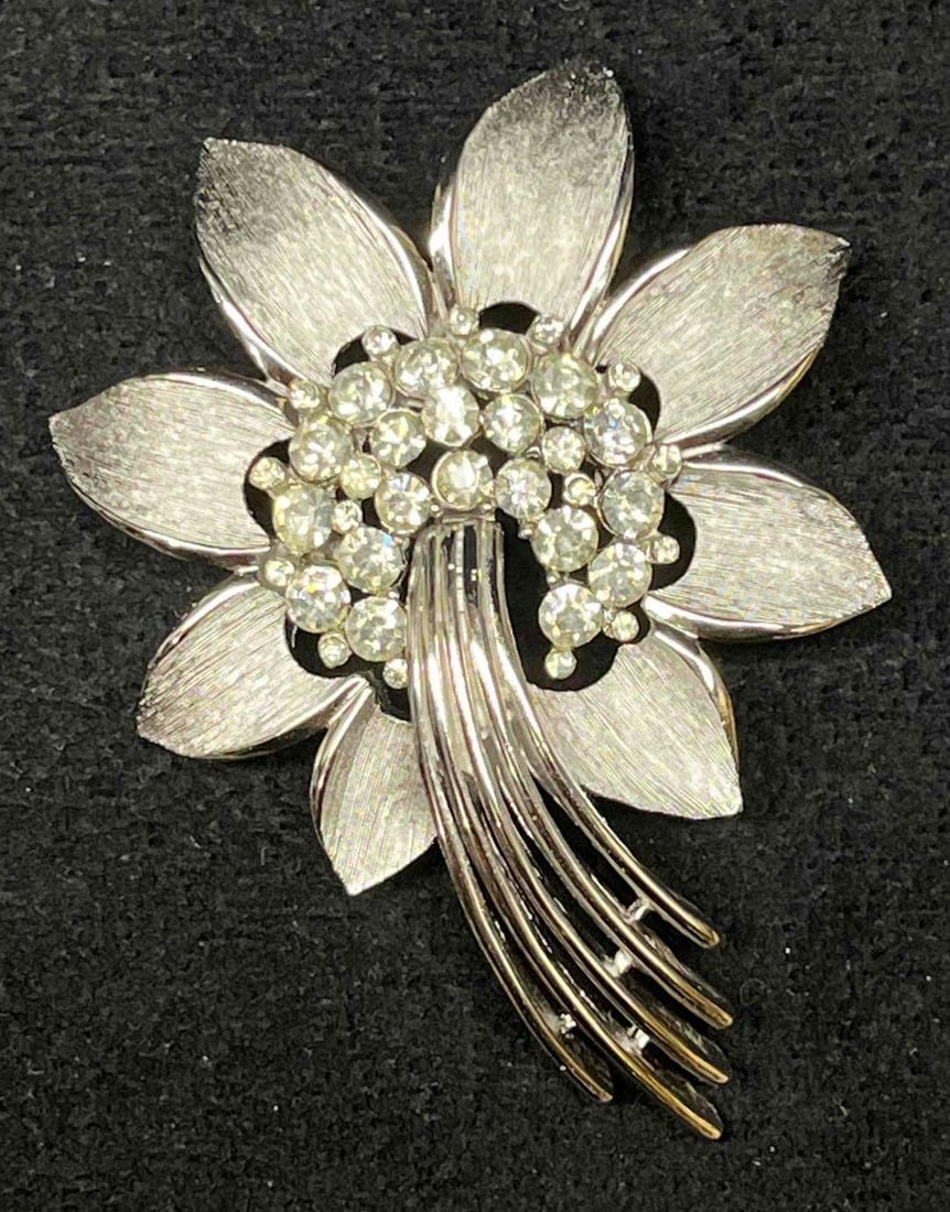 Vintage Signed Trifari Silver Tone Flower Brooch With Clear Rhinestones: This lot contains a Vintage Signed Trifari Silver Tone Flower Brooch With Clear Rhinestones. It is approx 2 1/2" x 1 3/4" x 1/2". Total weight is approx 0.8oz. Overall the brooch is in excellent pre o