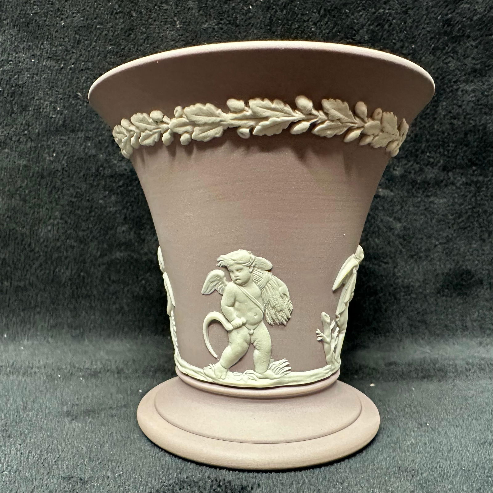 Lilac Purple Wedgwood Jasperware Four Season Cherub Vase: A purple lilac matte finish vase, Wedgwood, and their classic piece of pottery Jasperware range. Engraved on the bottom is Made in England, Wedgwood. The piece is a purple lilac and white coloring, an