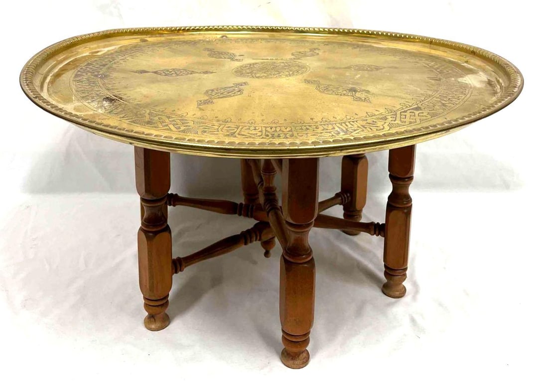 Moroccan Brass & Wood Folding Tray Table (K39): This lot contains a Moroccan Brass & Wood Folding Tray Table (K39). The Top is approx 26 1/4" x 26 1/4" x 1 1/4" and the stand folded is approx 17 1/2" x 4 3/4" x 13 3/4". The total weight i