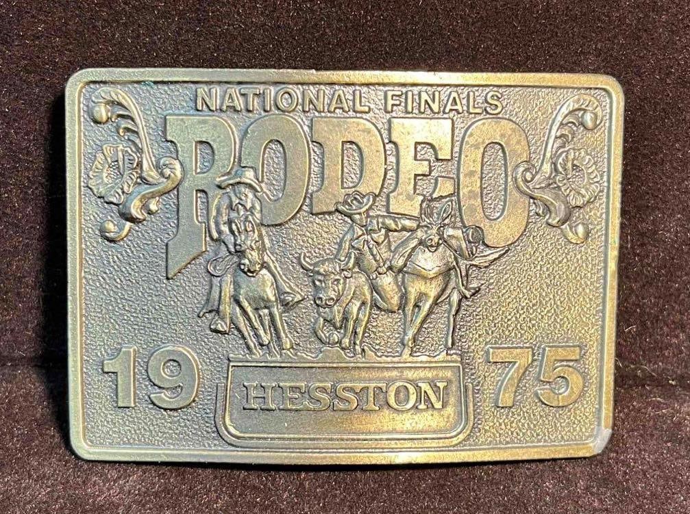 1975 Hesston Rodeo Belt Buckle National Finals (F18): This lot contains a 1975 Hesston Rodeo Belt Buckle National Finals (F18). It is approx 3 1/4" x 2 1/4" x 3/4" and it weighs about 0.4lbs. Overall the Belt Buckle is in good used condition with some li