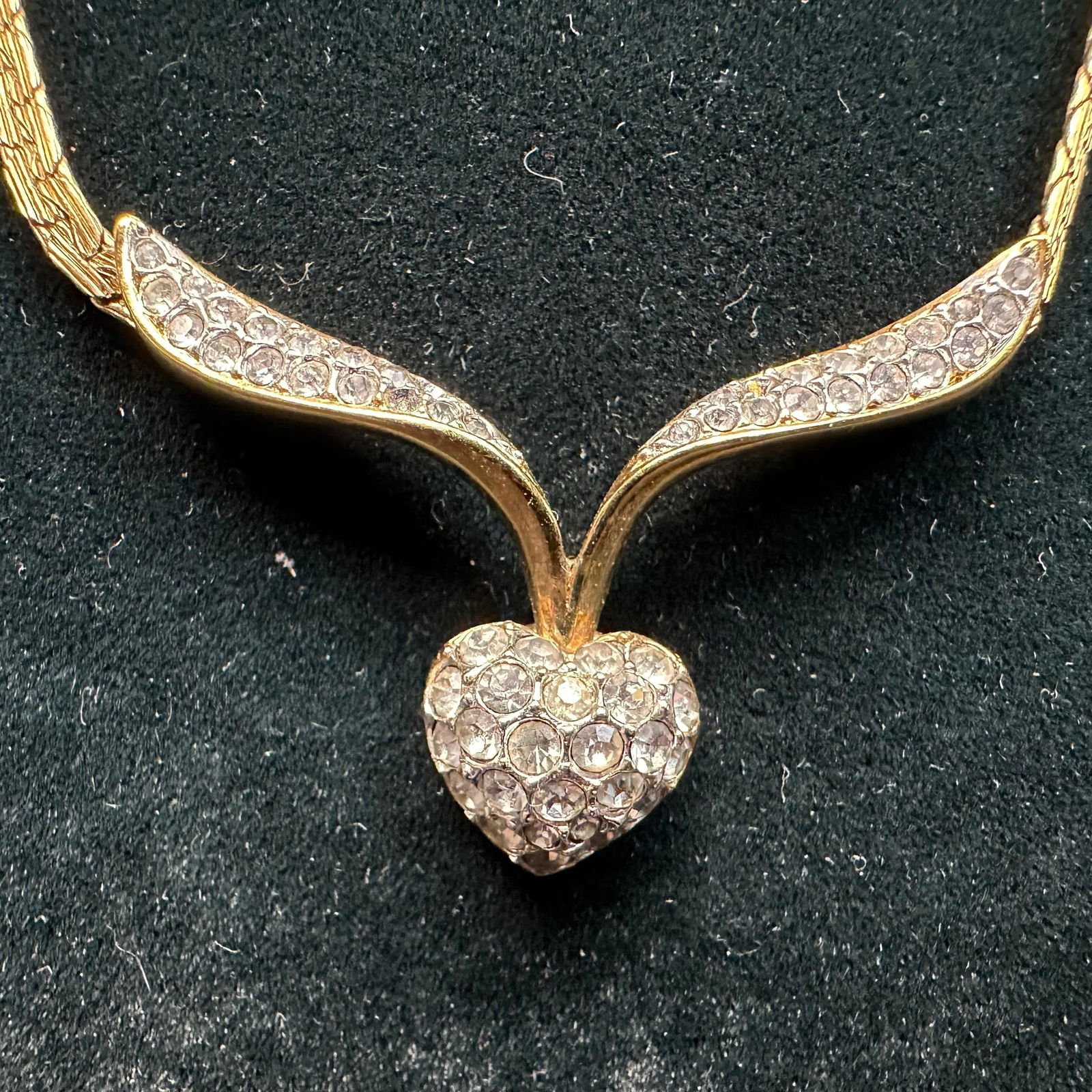 Gold Filled Heart Necklace with Rhinestones V Shaped: Gold-filled necklace featuring a v-shaped design accented with clear rhinestones and a heart-shaped pendant. Marked A & S on the back of the heart pendant. This item is in good pre-owned, previous