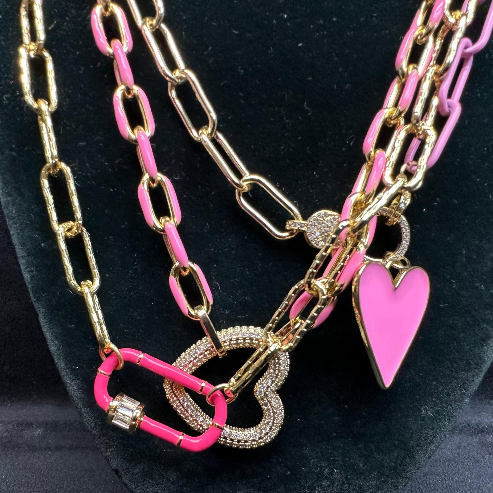 Melania Clara Assorted Gold and Pink Colored Necklace Heart Accent Chain Set M2: The Melania Clara necklace set features a magnet clasp closure. The necklaces have magnet extender clasp closures. Each necklace showcases modernist designs with gold-toned and rhinestone accents. The