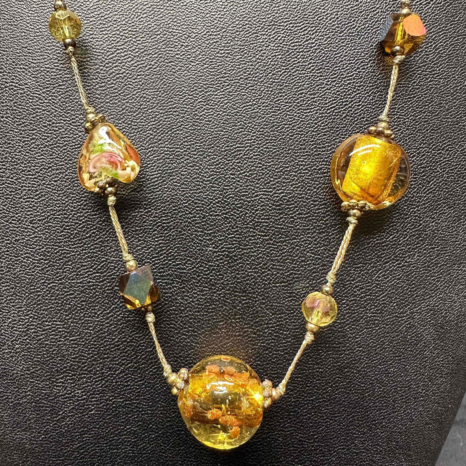 Floral Yellow Gold Venetian Murano Lamp Work Art Glass Necklace: Necklace with yellow and gold colored glass beads with beautiful hand painted designs on each. The necklace features floral, heart shaped, and copper colored accents. The necklace features a lobster c