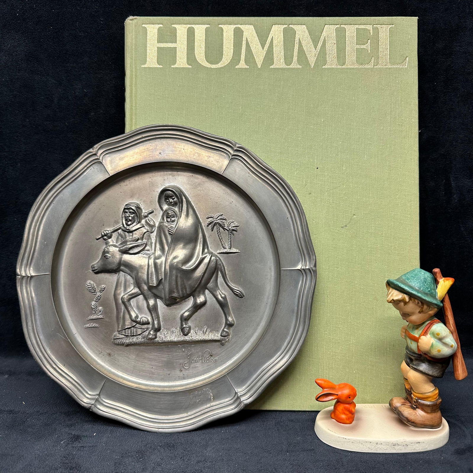 Hummel Goebel Lot Figure Plate Book: This lot includes three Hummel collectibles: a plate, a figure, and a catalog book. These items are in good pre-owned condition with noticeable light wear, markings, and surface scratches. Please refe
