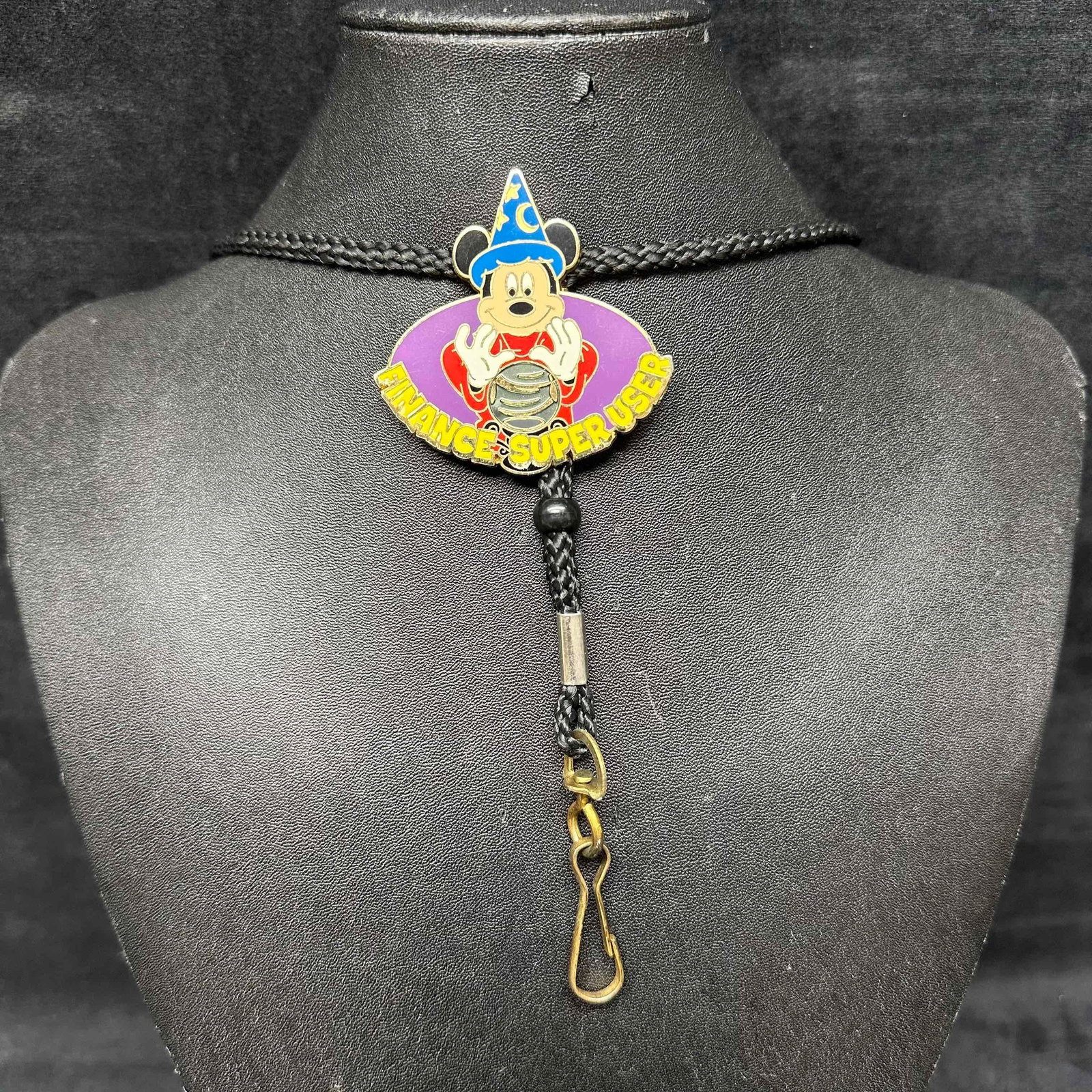 Sorcerer Mickey Mouse Disney Cast Member Bolo Tie Lanyard Medal: This is a classic sorcerer Mickey bolo lanyard features the words, "finance super user". The bolo lanyard attachment is one of a series exclusively for Disney Cast Members. This item is in goo