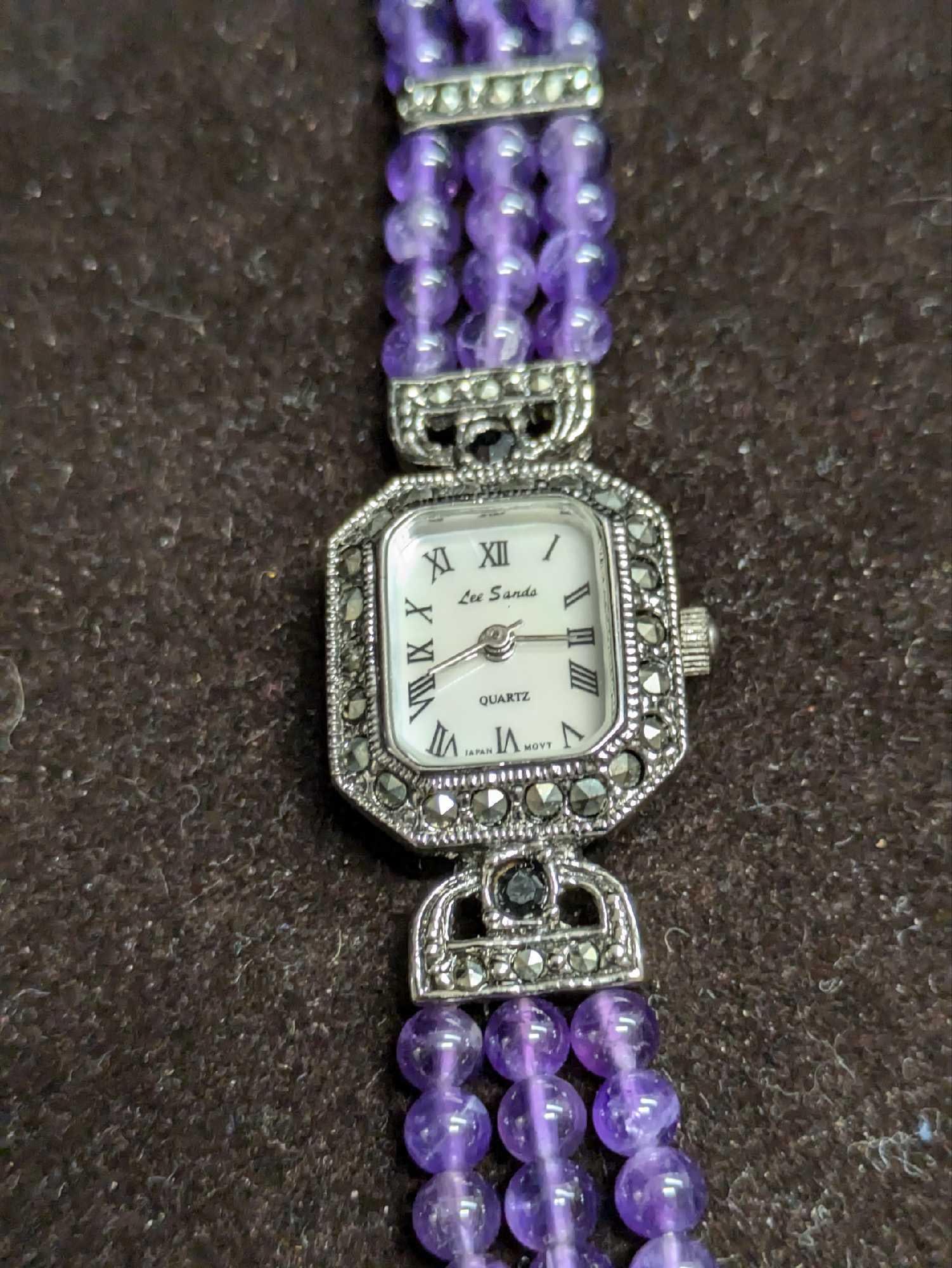 Lee Sands Purple Beaded Marcasite Watch: Lee Sands Purple Beaded Marcasite Watch. Marcasite links, triple layer round beaded purple stones, interlocking with inset marcasite, and foldover clasp. Oval mother-of-pearl dial, black rotation