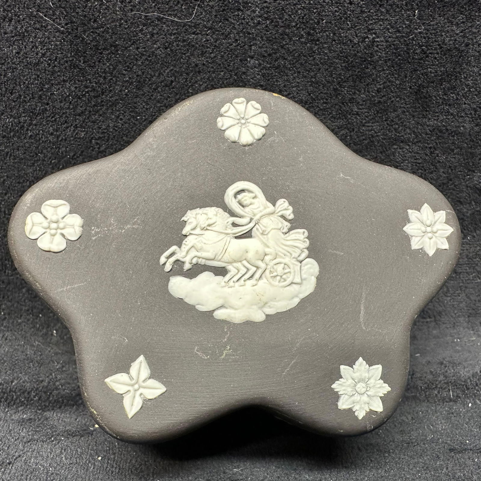 Wedgwood Matte Black Jasperware Star Shaped Trinket Box: A black trinket jewelry pin dish, Wedgwood, and their Jasperware range. Engraved on the bottom is Made in England Wedgwood. The piece is a black and white coloring and also has a unique design. The it