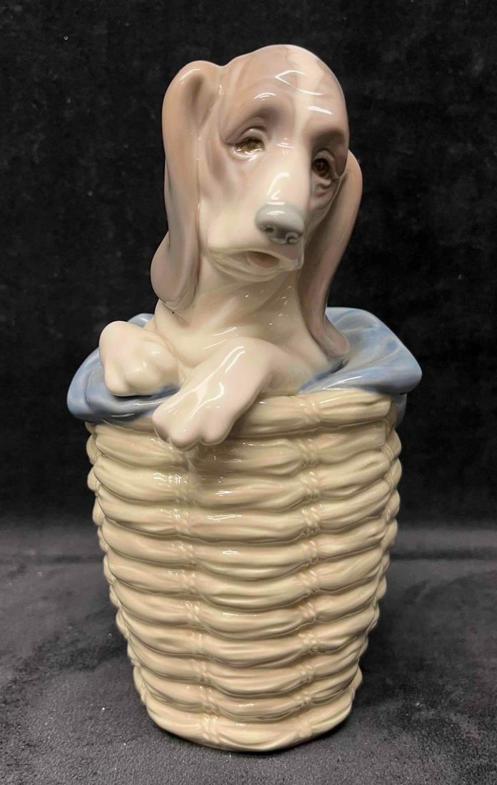 Vintage Retired Lladro Porcelain Dog In Basket: This lot contains a Vintage Retired Lladro Porcelain Dog In Basket. Hand made in Spain. It is approx 3" x 4 1/2" x 7 1/2". Total weight is approx 1.5lbs. Overall the Vintage Lladro is in good pre