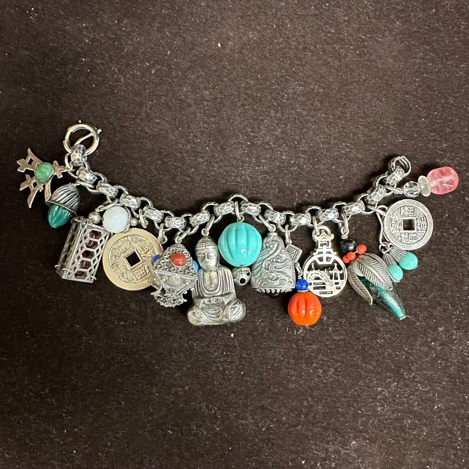 Napier Asian-Inspired Silver Toned Charm Bracelet with Mixed Charms Buddha Dragon Lantern: Vintage Napier charm bracelet featuring a heavy textured chain marked NAPIER with multiple Asian-themed charms, including a Buddha figure, red glass lantern charm, carved turquoise-colored bead, drago