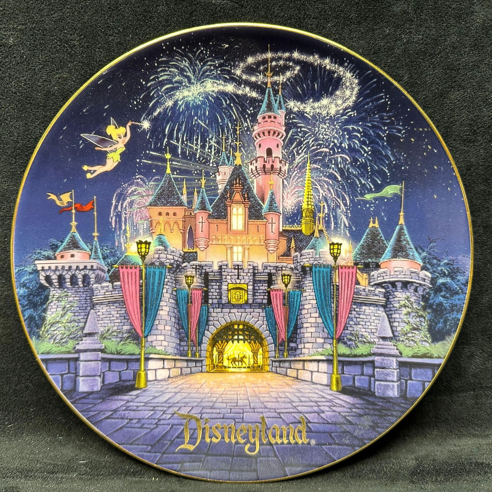 Disneyland Sleeping Beauty Castle Disney Decorative Plate: Disneyland collectible decorative plate featuring Sleeping Beauty Castle with Tinker Bell and fireworks. Made exclusively for Disneyland Theme Park. Ceramic construction, gold-tone rim, marked on reve