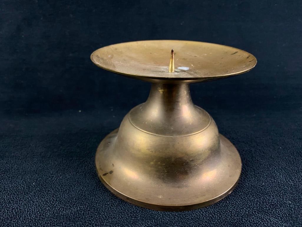 Brass Candle Holder: Brass Candle Holder Wide-base brass candleholder. Made in India, and has a point to stick into the bottom of the candle. Has some scratches and oxidation on the surface of the brass. Approximate siz