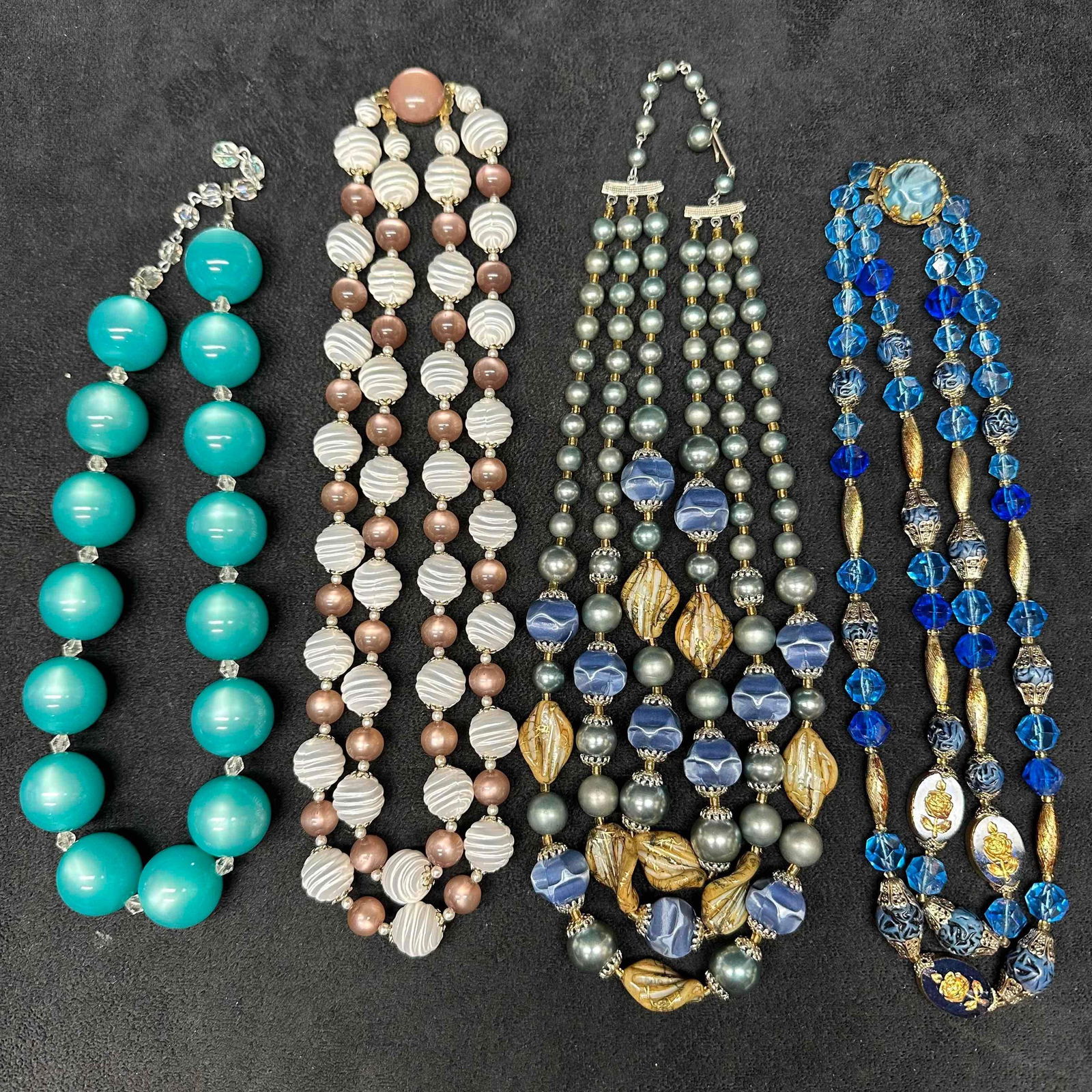 Plastic Bead Costume Jewelry Necklace Set of Four G83: Various costume jewelry necklaces, four pieces included with plastic beads. Light noticeable wear throughout the necklace set. Each necklace has several different accents. The turquoise colored beaded