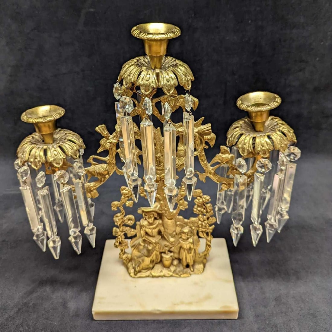Vintage Gilt Brass Candelabra With Crystal Prisms (F37): Vintage Gilt Brass Candelabra With Crystal Prisms (F37). Is approx 15" x 5 1/2" x 15 1/2" and it weighs 9.20lbs. The Candelabra shows a woman and a small girl standing by a tree. It is made of gilt