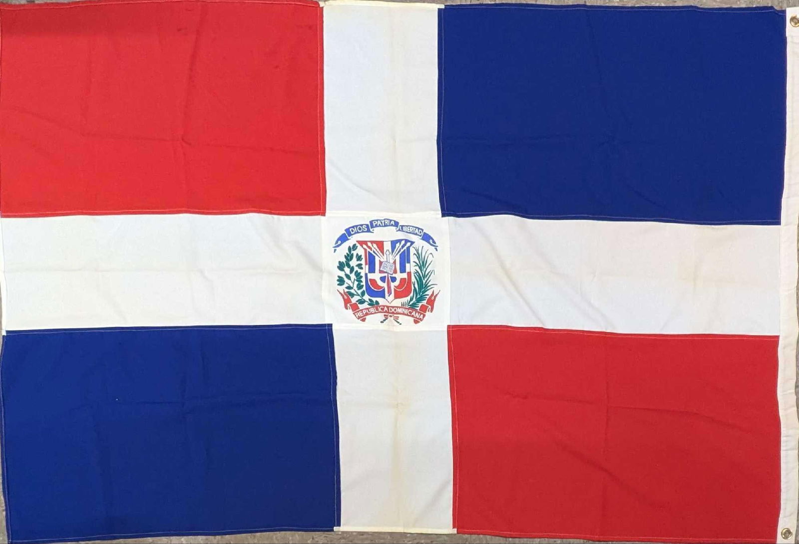 Vintage 43" x 65" Dominican Republic Flag: Vintage 43" x 65" Dominican Republic Flag. This unmarked flag appears to be made of either nylon or polyester. Folded up, it is approx 2" x 14"x 9" and it weighs 0.90lb. The flag is noticeably