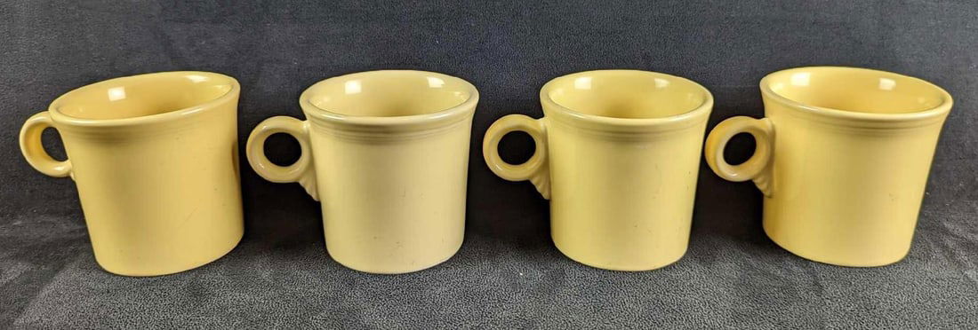 4 Yellow Sunflower HLC Fiesta Mugs: 4 Yellow Sunflower HLC Fiesta Mugs. Each is approx 5" x 2 1/2" x 3 1/2" and together they weigh 3.77lbs. The mugs are in good, used condition with some signs of wear and scratches inside the mugs and