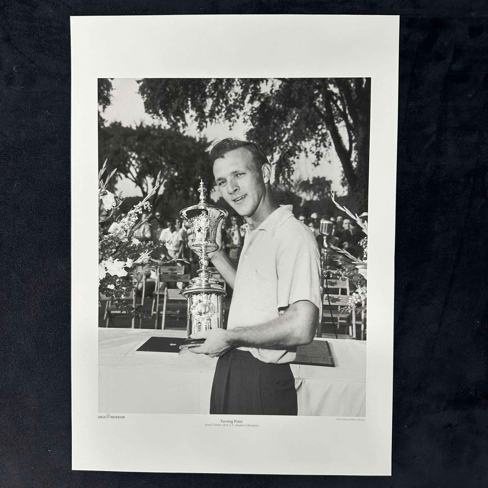 Arnold Palmer "Turning Point" 1954 U.S. Amateur Champion USGA Museum Black and White Photo Print: Black and white photograph print depicting a young Arnold Palmer proudly holding the U.S. Amateur Championship trophy in 1954. This iconic moment, often referred to as a career turning point, is part