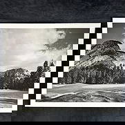 Black and White Inkjet Photograph Print Mountain Golf Course with Sheer Cliff Face: Black and white inkjet print depicting a golf course framed by towering cliffs and evergreen forest. The rugged rock face rises behind the tree line, evoking the grandeur of alpine landscapes. Wide