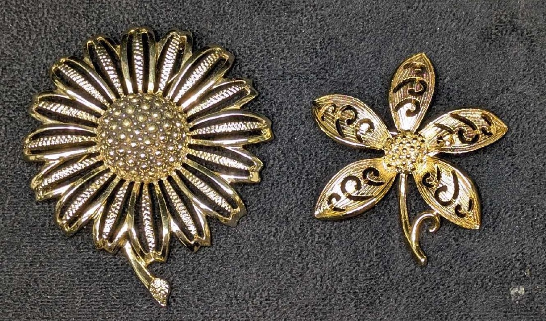 Vintage Gold Tone And Gold Plated Flower Brooches Sarah Coventry: This lot includes: (1) Sarah Coventry Sunflower Gold Tone Brooch. This is approx 2 1/2" x 1/2" x 3 1/4". (1) Gold Plated Flower Brooch. The maker and date of creation is unknown. This is