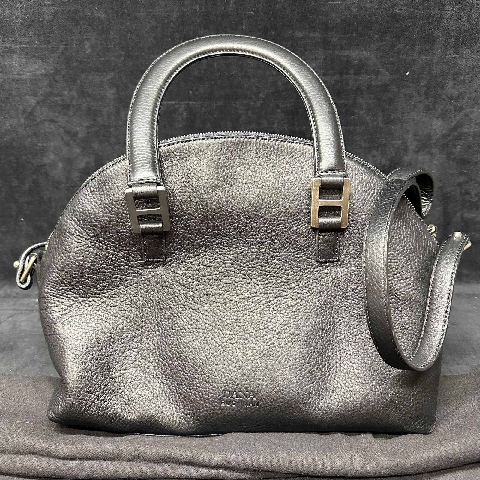 Dana Buchman Black Leather Satchel Handbag with Shoulder Strap: Dana Buchman black pebbled leather satchel featuring dual top handles, detachable shoulder strap, and zip-top closure. Interior with fabric lining and a zip pocket. Includes original Dana Buchman dust