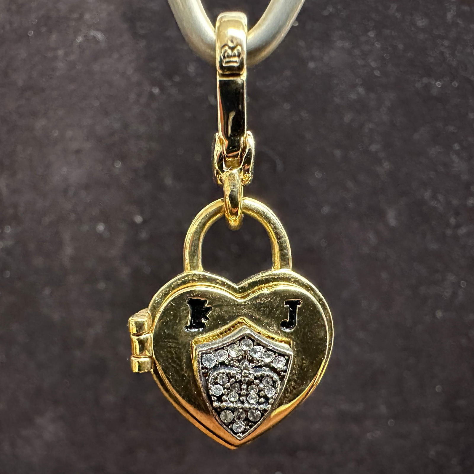Juicy Couture Heart Locket Charm with Crystal Accent: Juicy Couture gold-tone heart locket charm featuring a crystal pave accent. The charm is finished with a lobster clasp for easy attachment to bracelets, necklaces, or handbags. Marked Juicy Couture. P